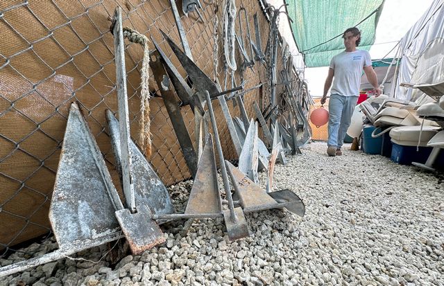 Jack Micciche walks along an aisle showcasing boat anchors.