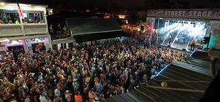 An outdoor venue full of people at a concert.