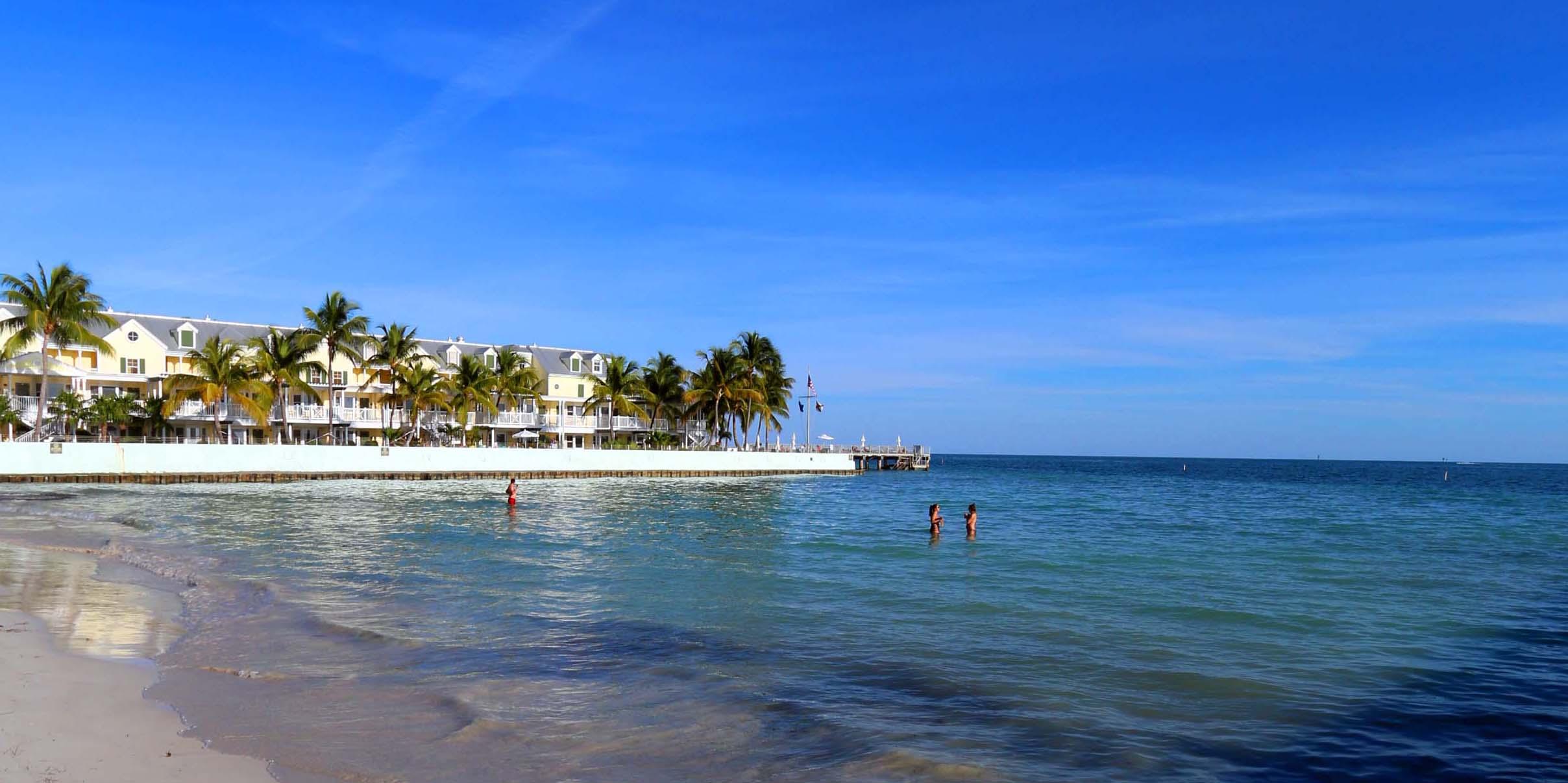 A beach scene with buildings in the background.