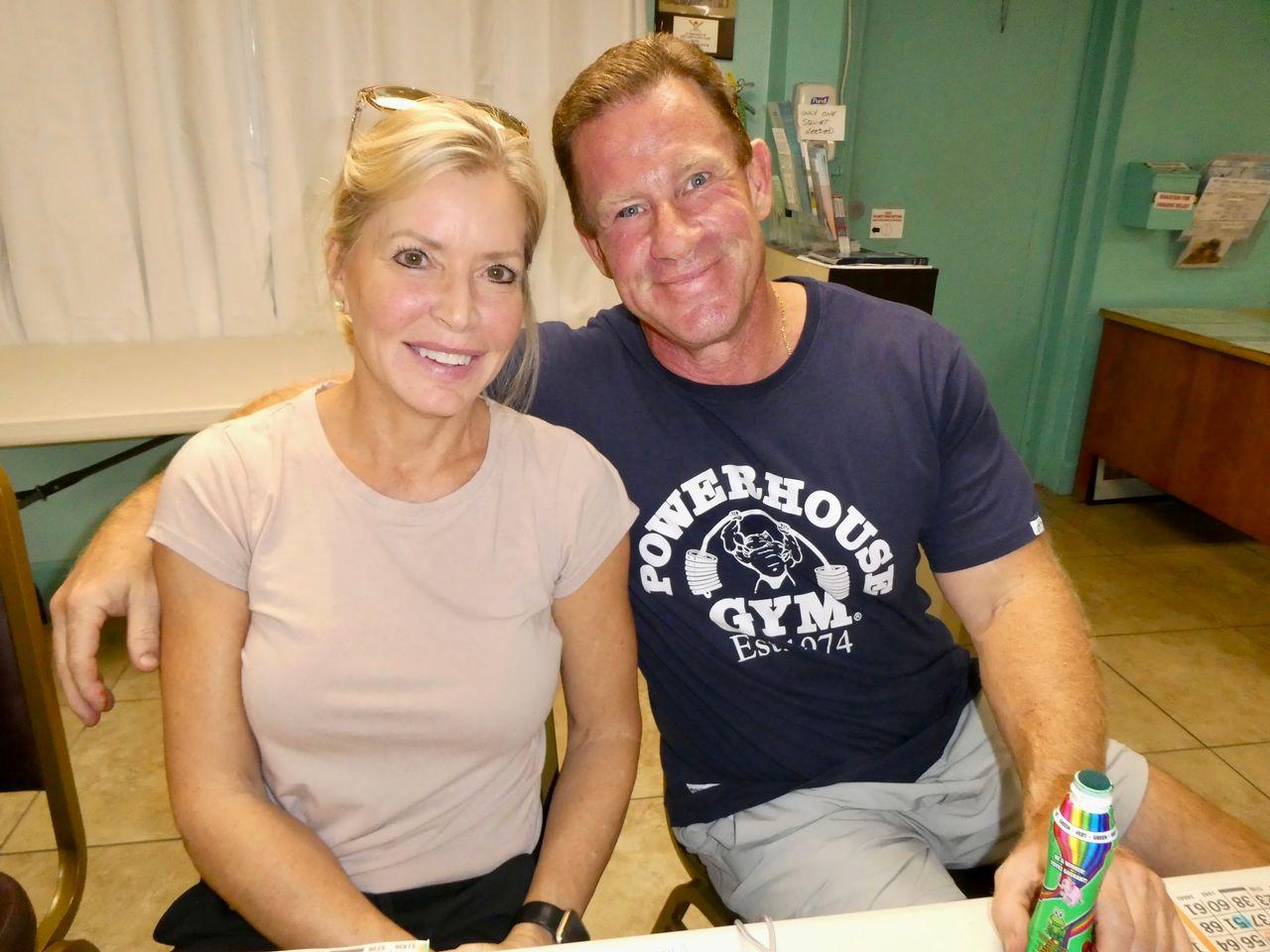 Smiling man and woman sitting together indoors.