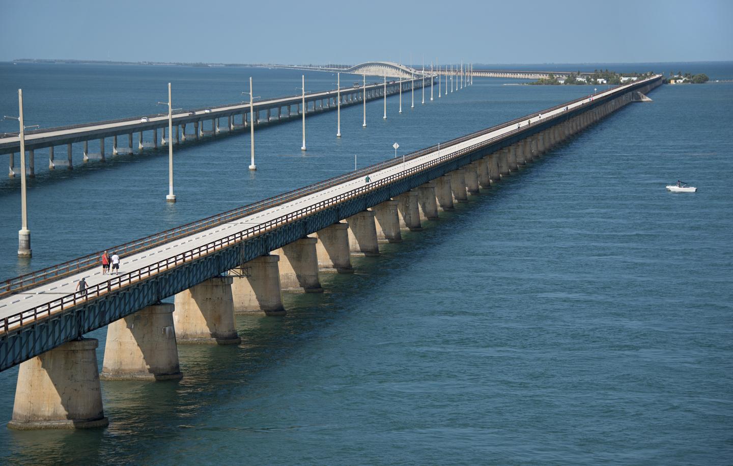 Dual bridges stretch across expansive blue water under a clear sky.