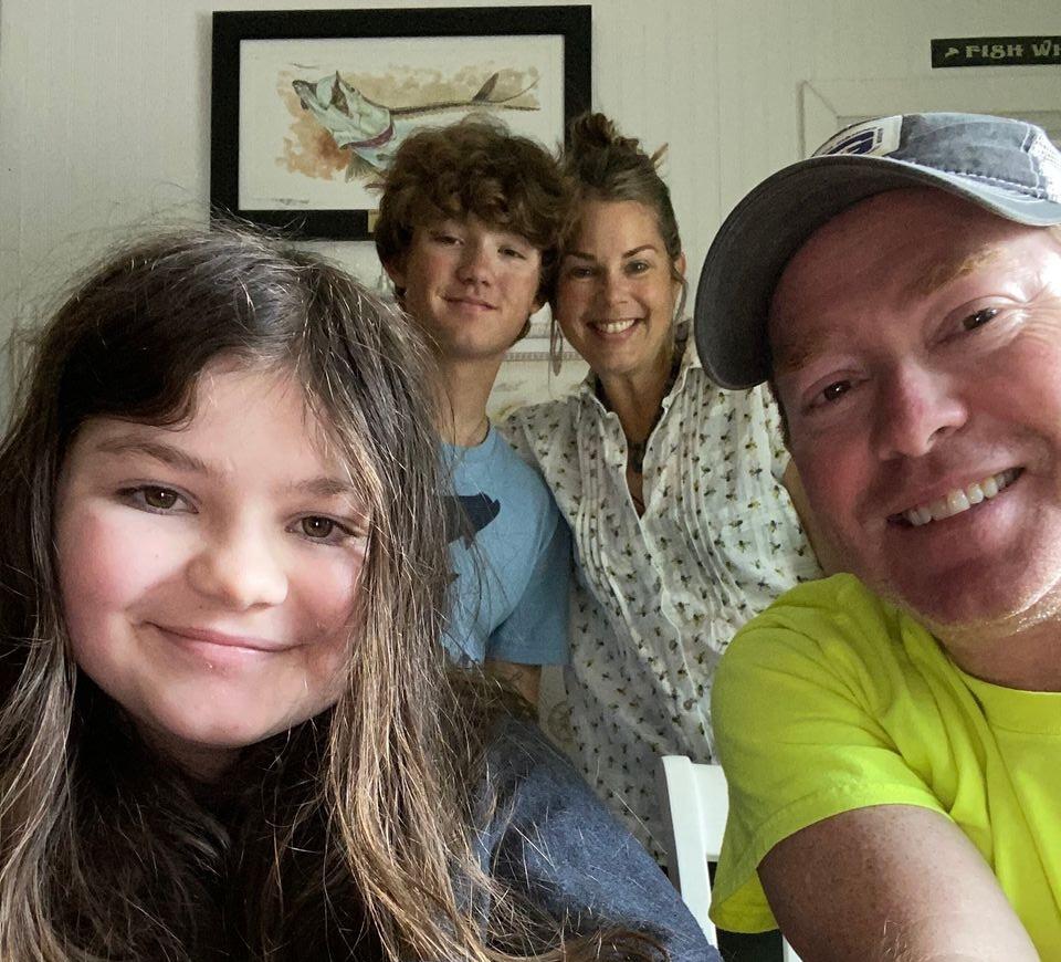 A group of four people smiling indoors.
