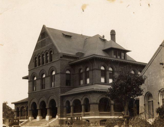 Historic brick building with arched windows and a steep roof.