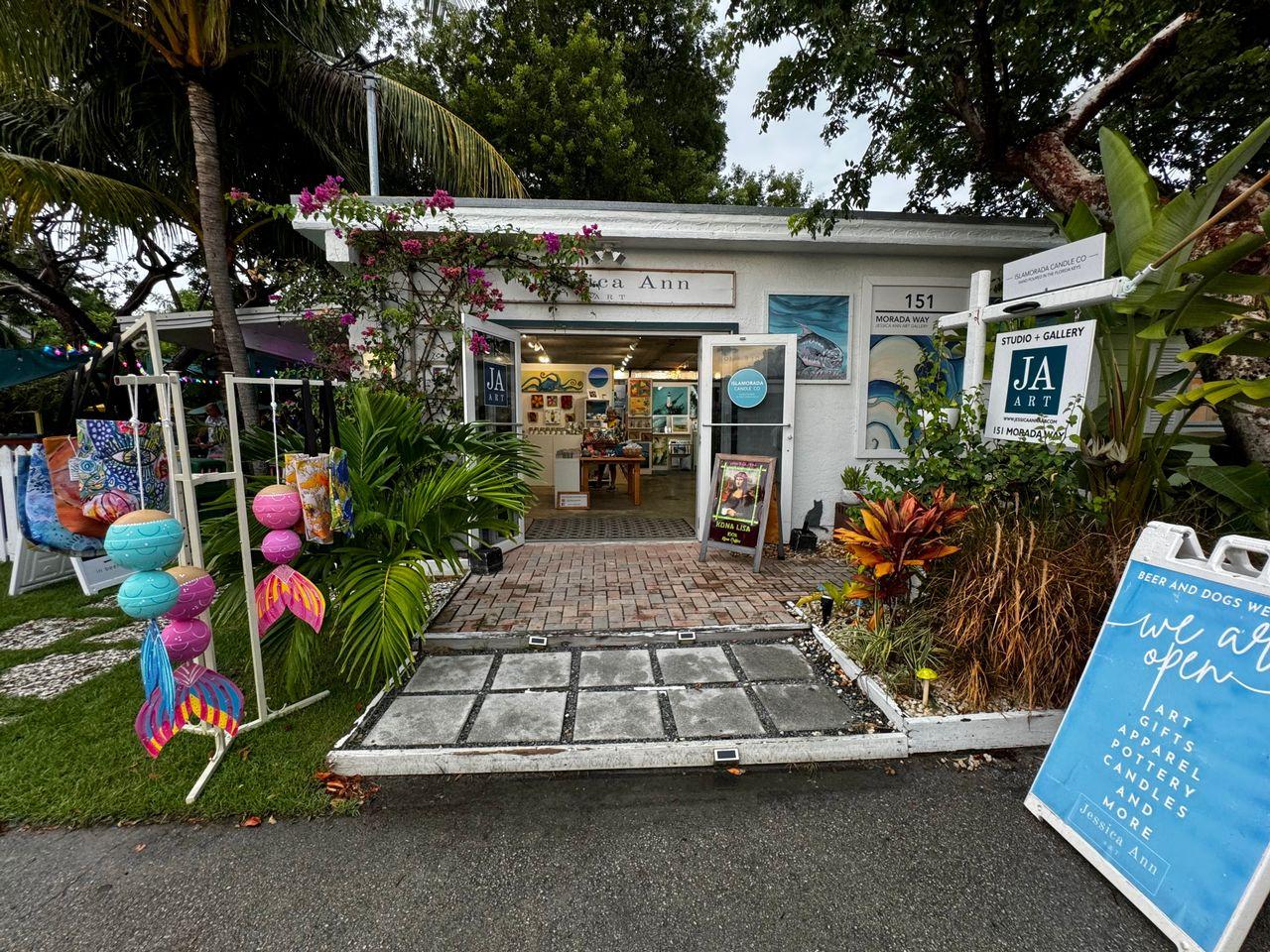 Small tropical gift shop with colorful decorations and plants outside.