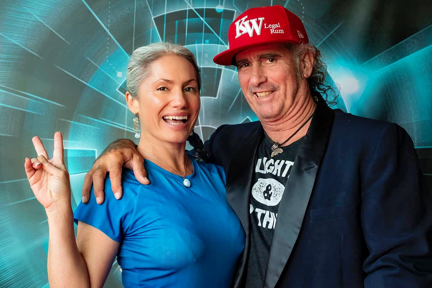 Smiling woman and man in red cap posing together.