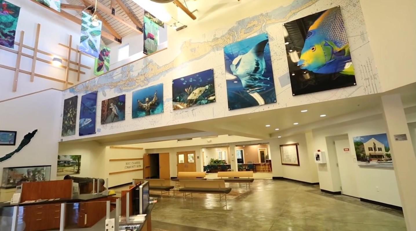 Spacious lobby with ocean-themed paintings on the wall.