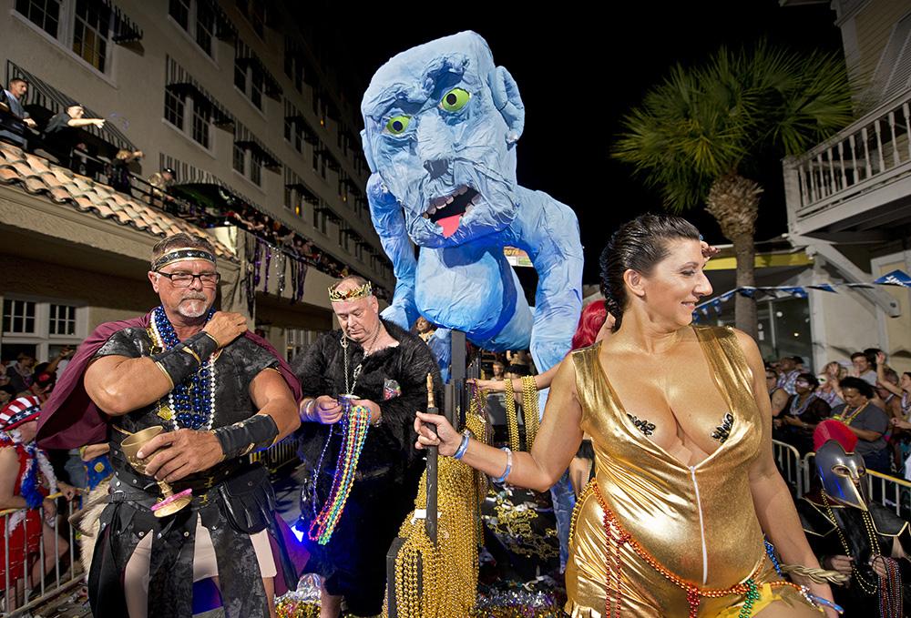 Fantasy Fest parade with festive costumes and a large blue puppet.