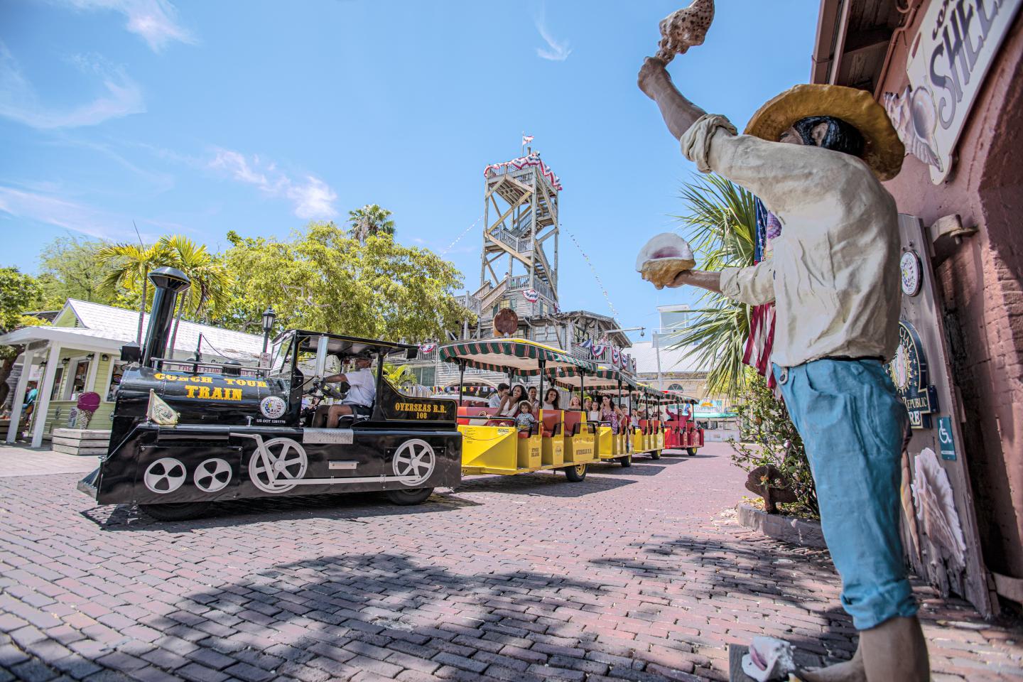 Model train and figure in a colorful outdoor theme park setting.