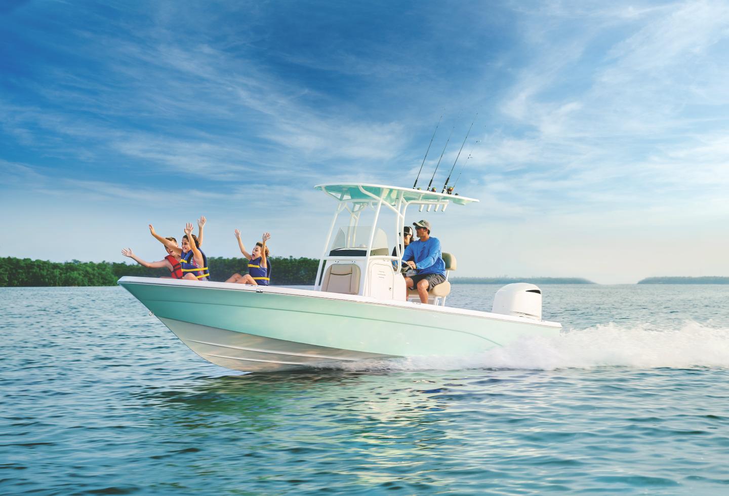 Boat speeding on water with people cheering, under a clear blue sky.