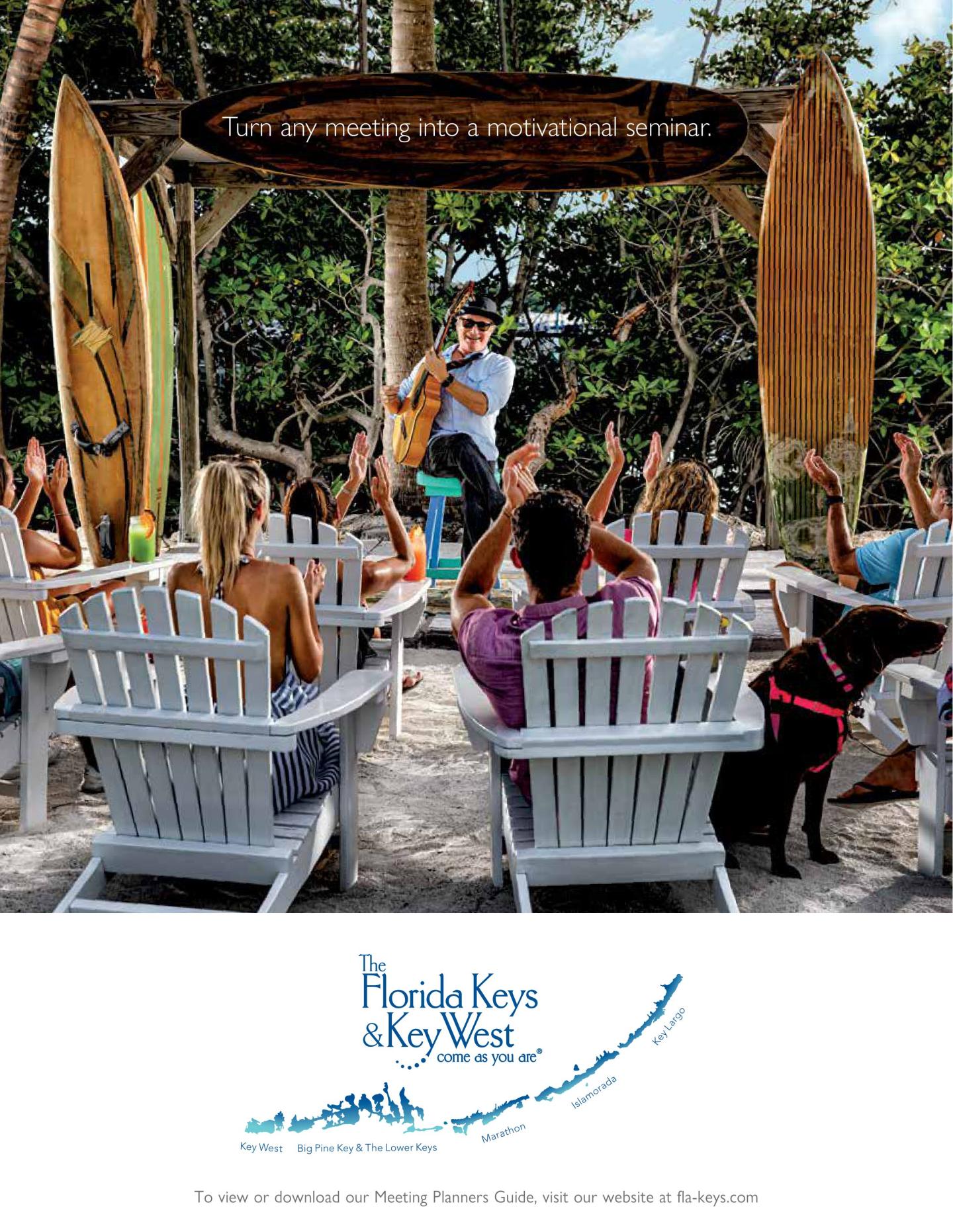 Musician performs for seated outdoor audience under palm trees; relaxed, tropical setting.