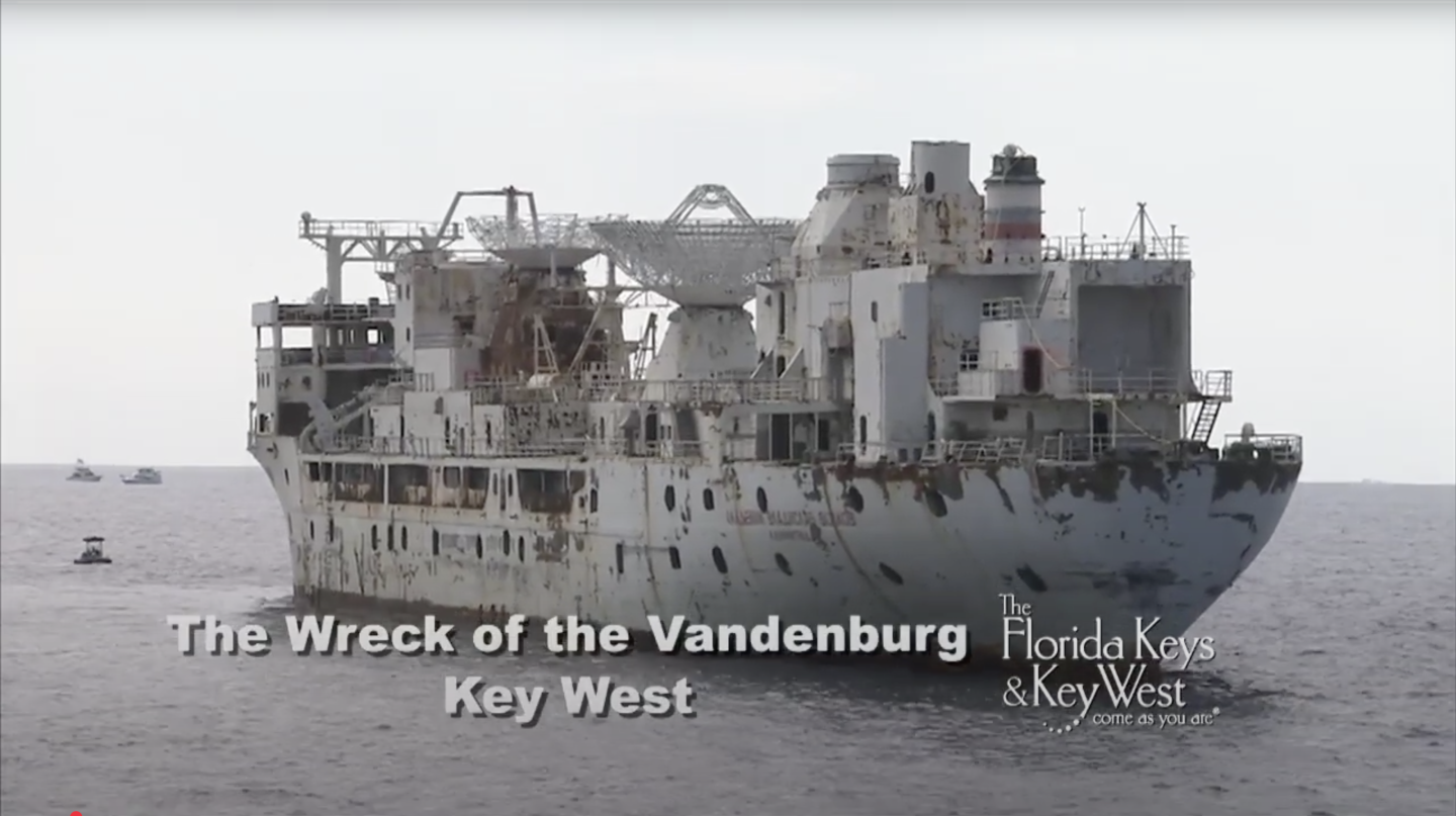 Rusty shipwreck in the ocean under an overcast sky.