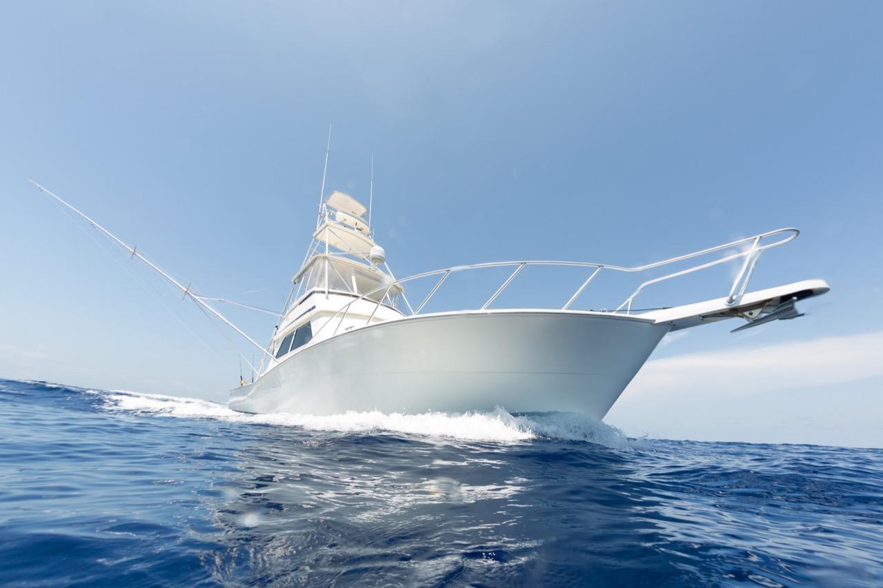 Sport fishing boat on open sea under a clear blue sky.