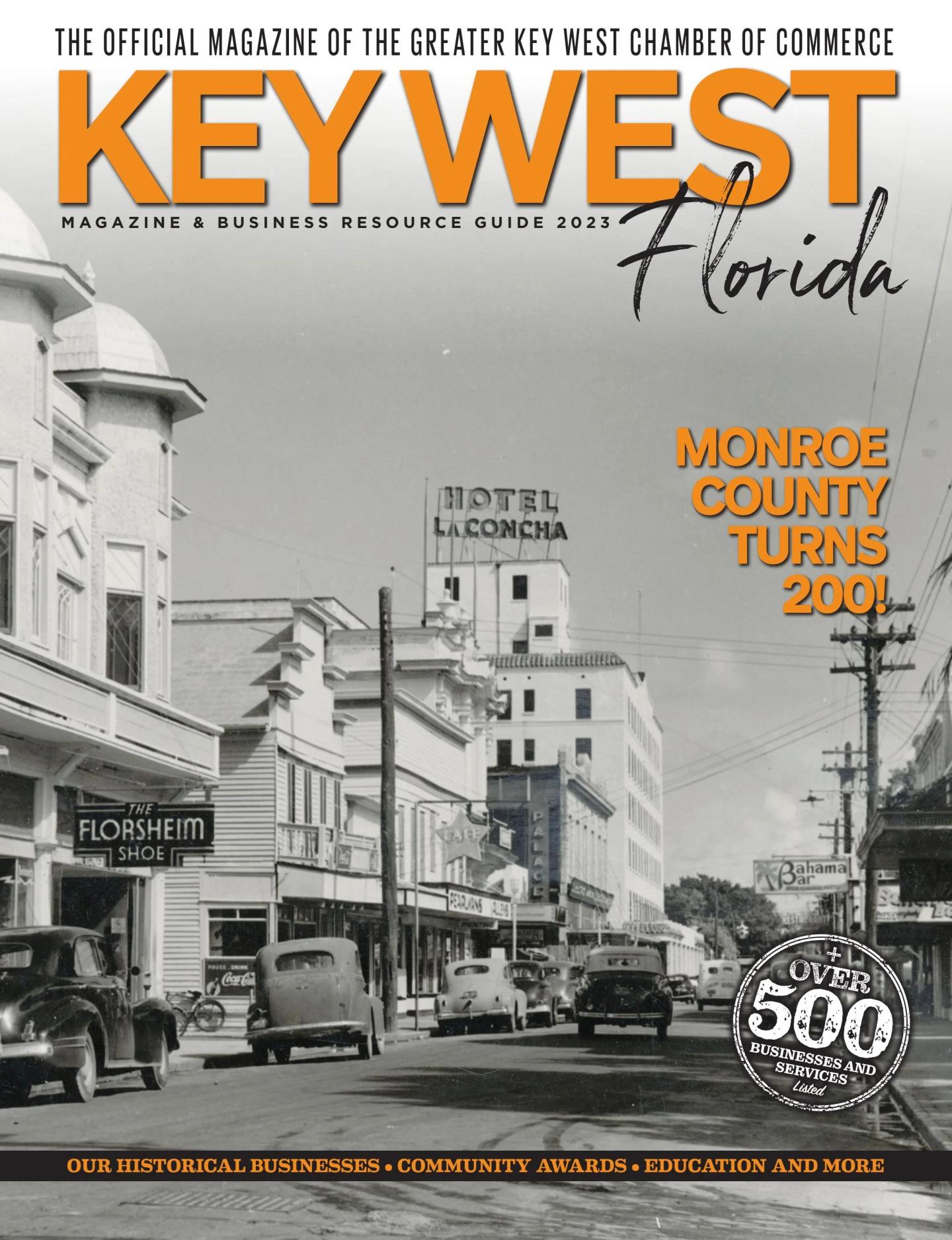 Magazine cover with a vintage photo of a Key West street, cars, and historic buildings.