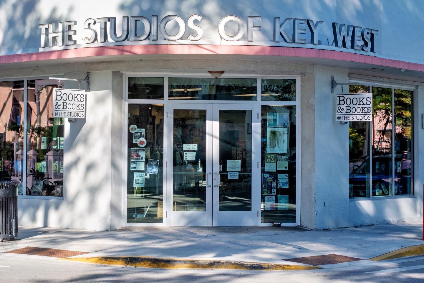 Facade of The Studios of Key West with glass doors and posters.