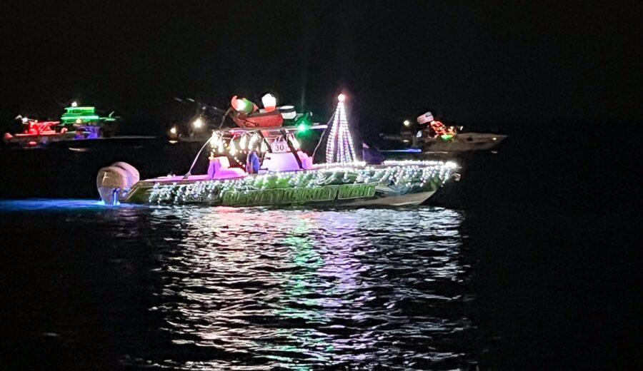 Boats decorated with colorful lights on a dark waterway.