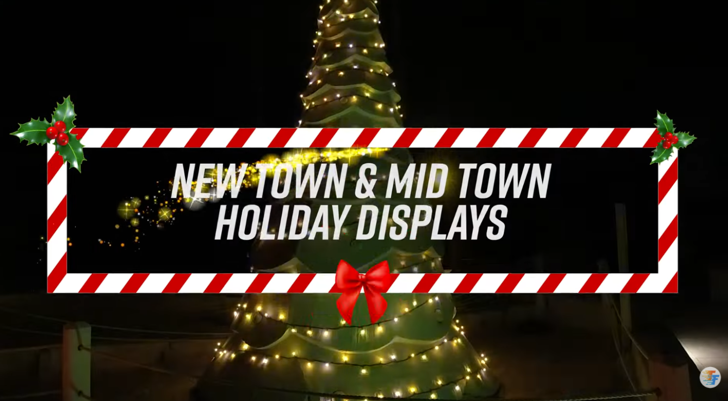 Holiday lights on tree with candy cane border and text.