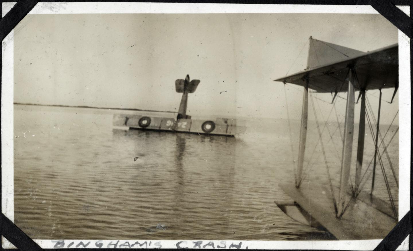 Seaplane sinking in calm water with wings partially submerged.