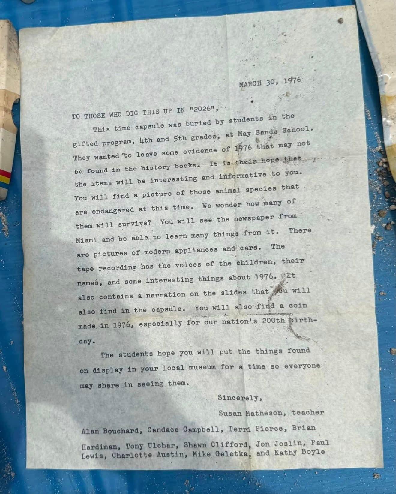 Typed letter on aged paper, placed on a blue surface.