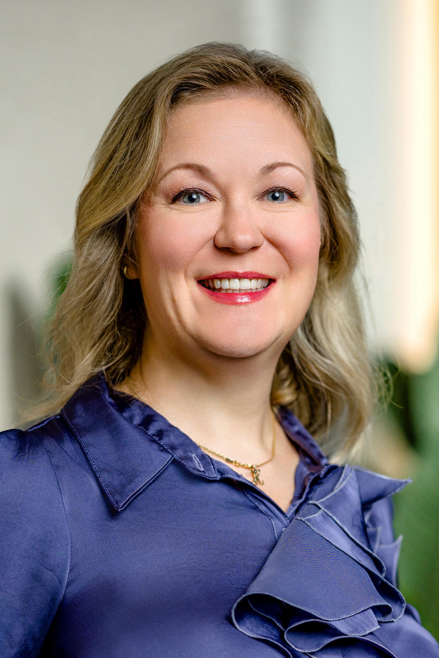 Smiling woman in a blue blouse.