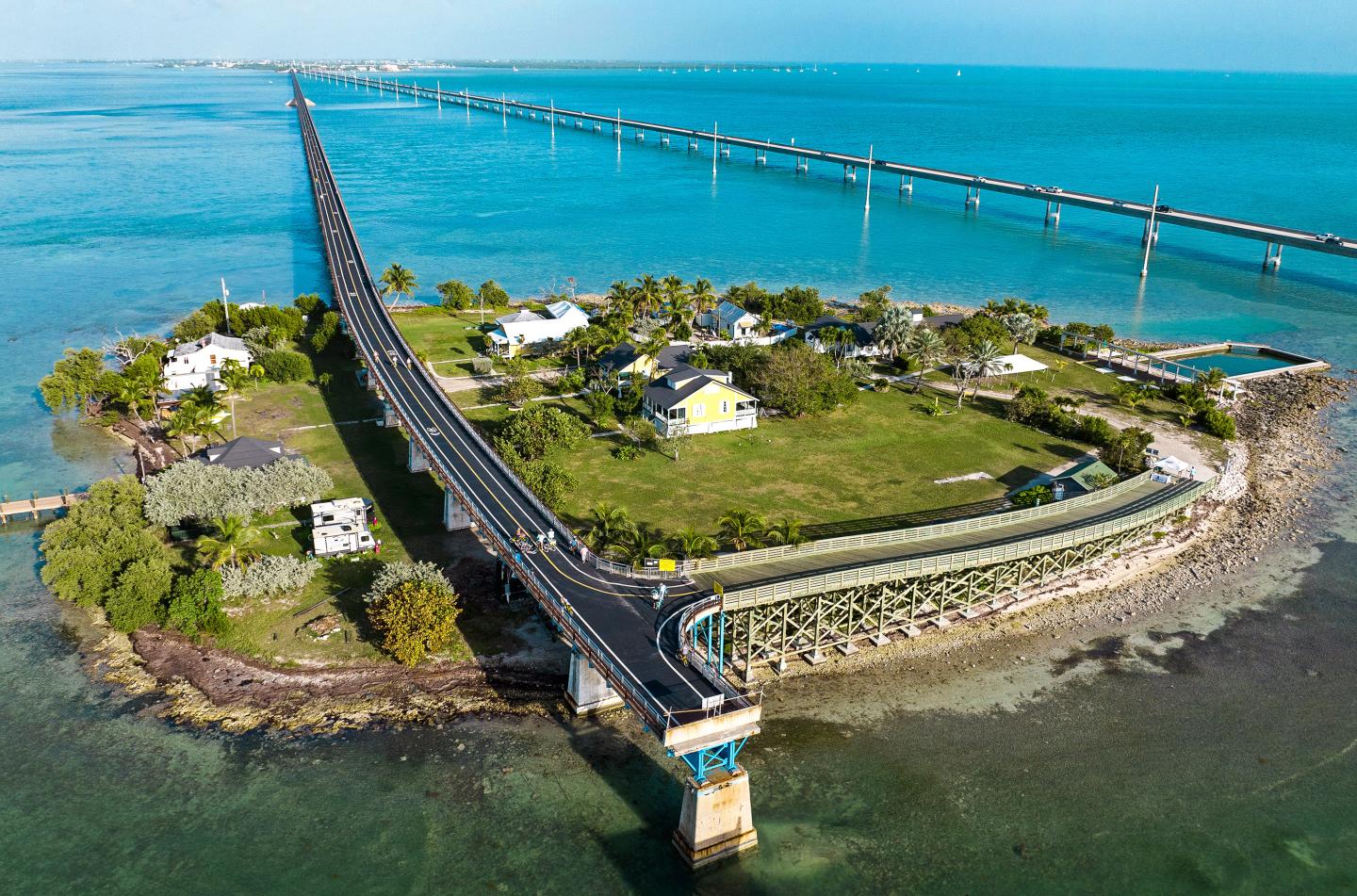 Bridge extending over turquoise water to an island