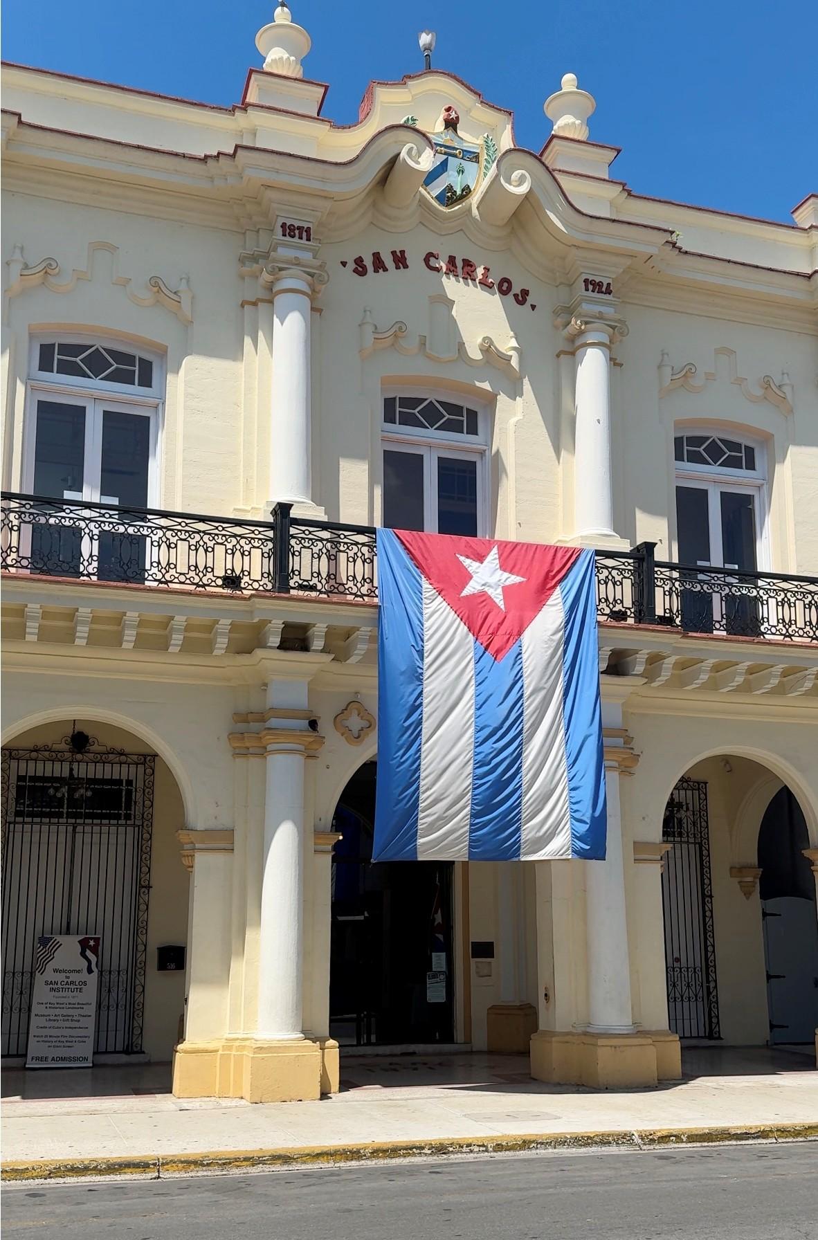 Historic building with a large Cuban flag hanging on the facade.