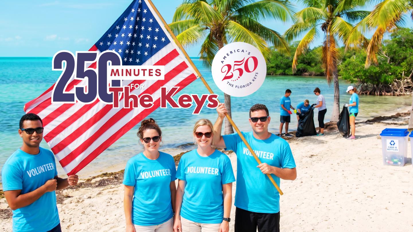 Four people in blue shirts on a sunny beach holding American flags.