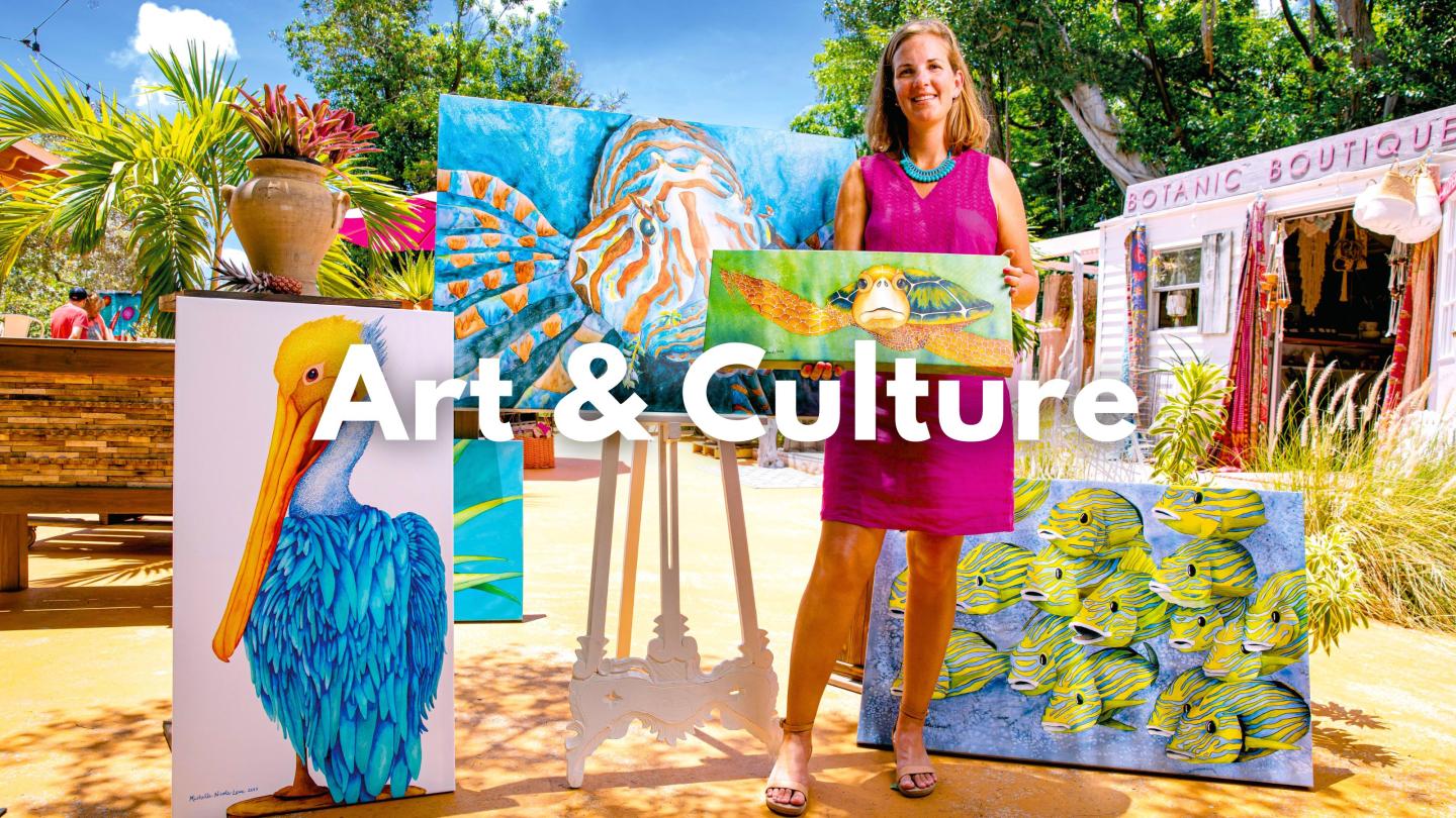 Woman in pink dress holding a colorful painting outdoors.