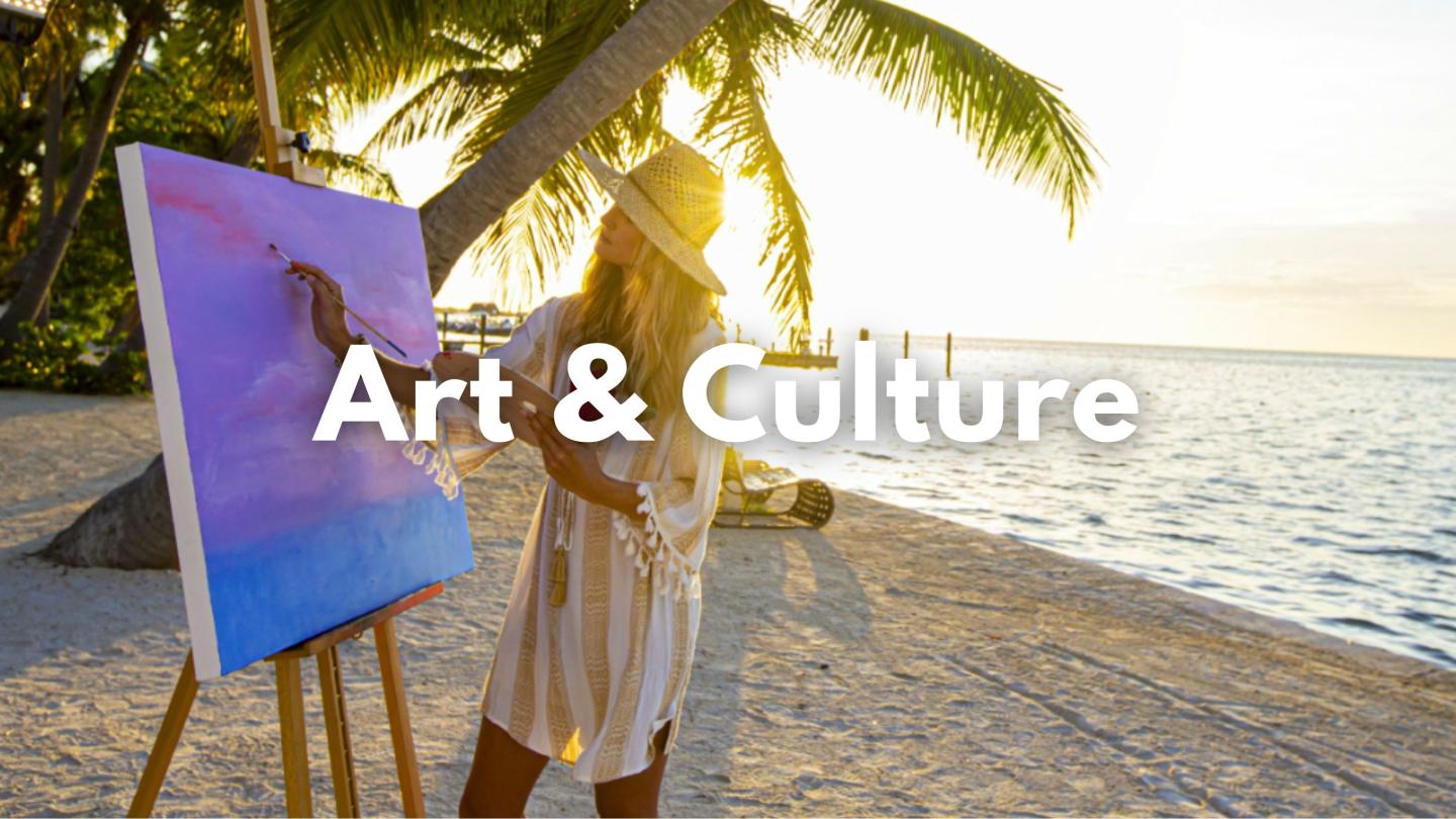 Artist painting on beach at sunset, palm trees nearby.