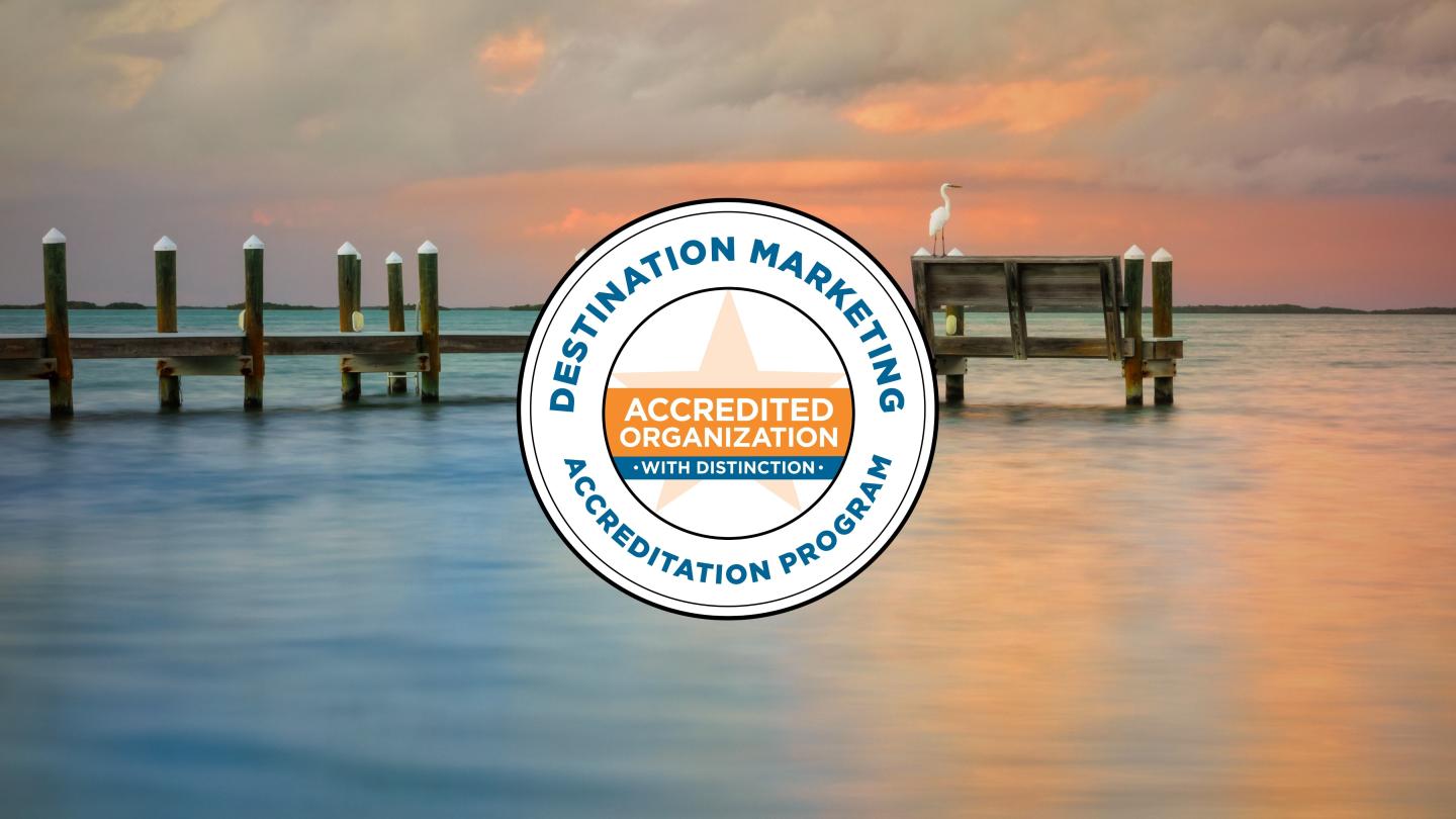 Seaside pier at sunset with accreditation logo overlay.