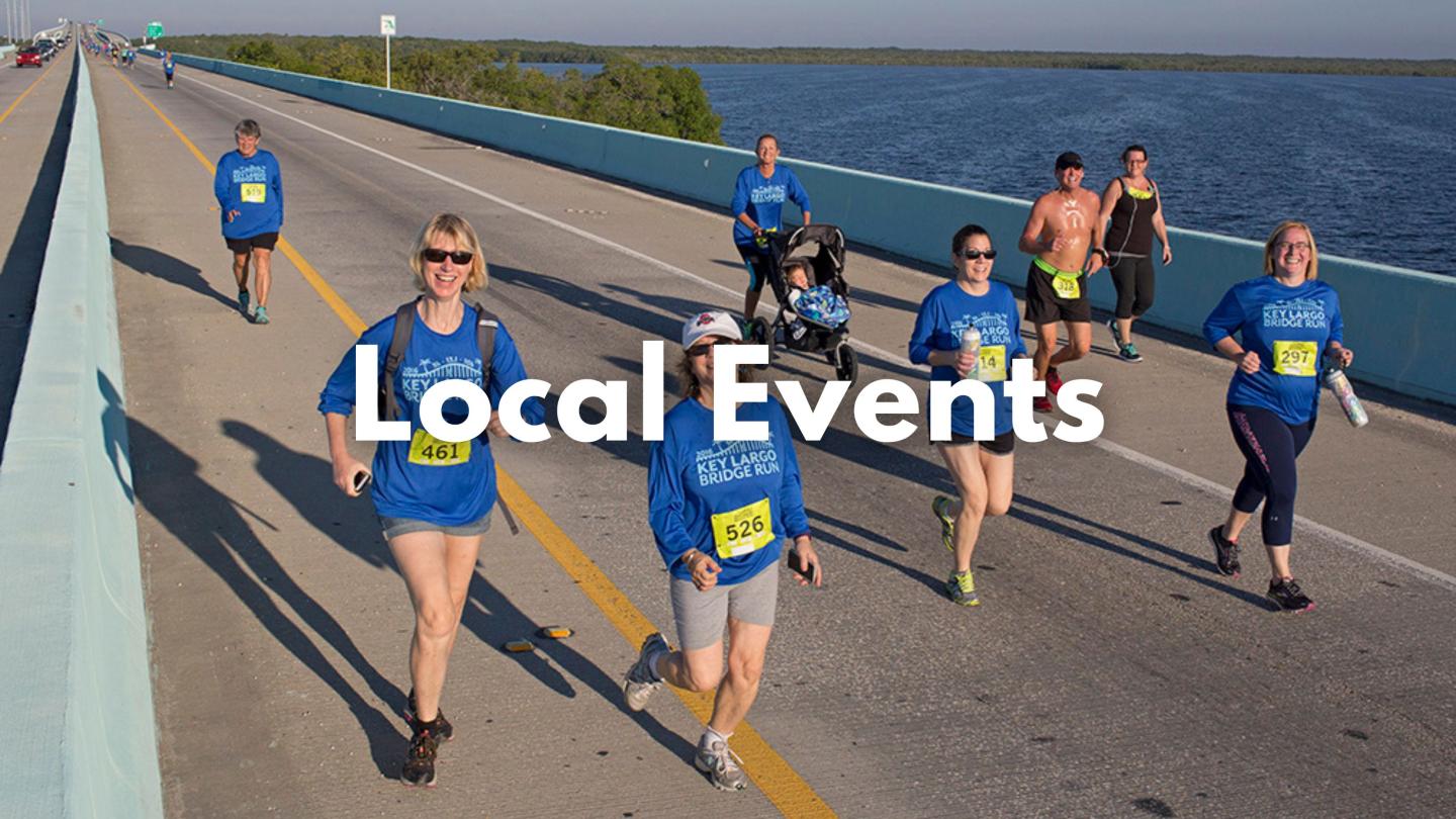Runners in blue shirts on a bridge during a race.