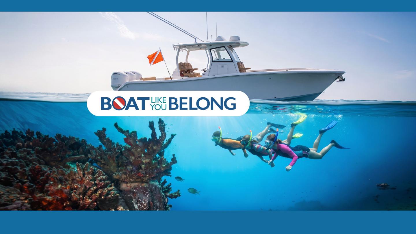 Snorkelers explore coral reef with boat above.