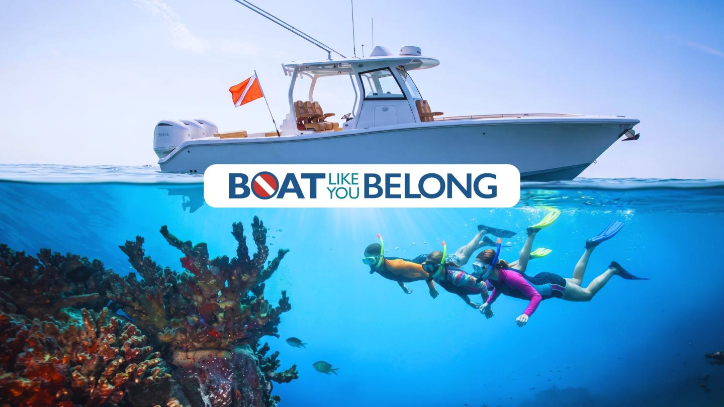 Boat above water, snorkelers explore vibrant coral reef below.