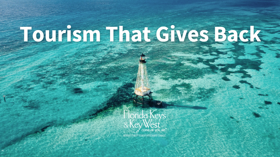 Aerial view of a lighthouse on turquoise water.