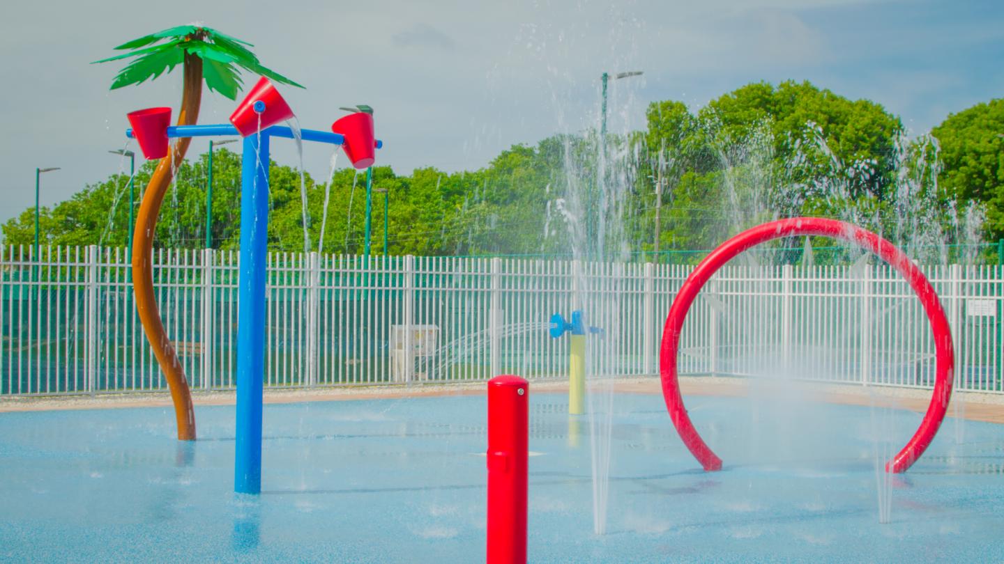 Colorful splash pad with water fountains and play structures.