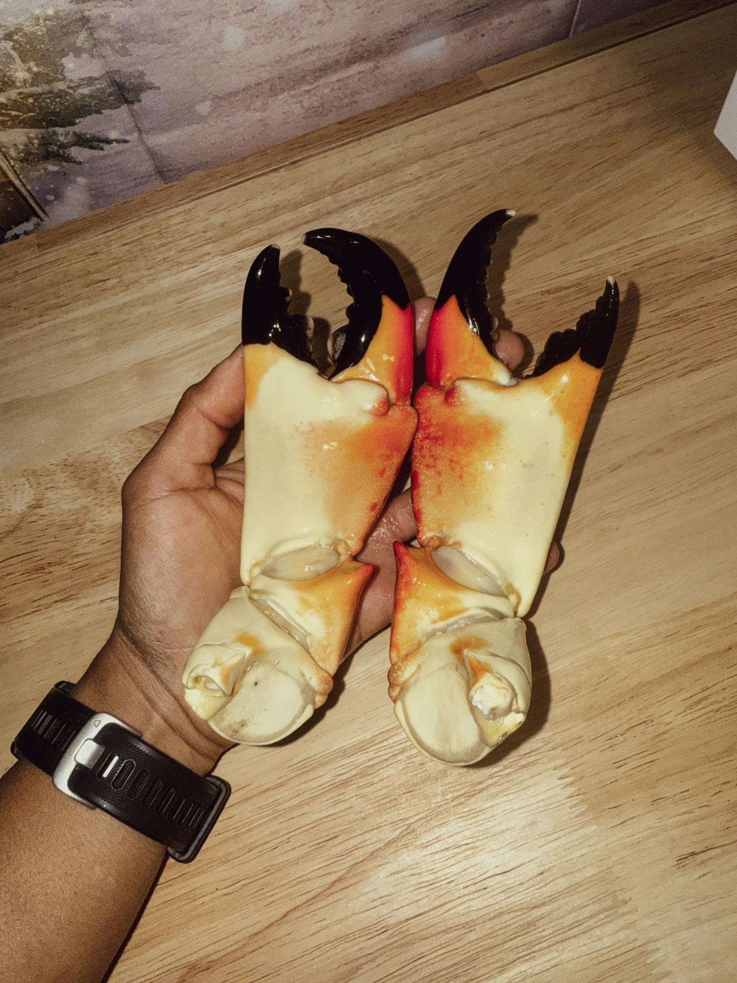 Hand holding two small wrapped bouquets with dark flower petals.