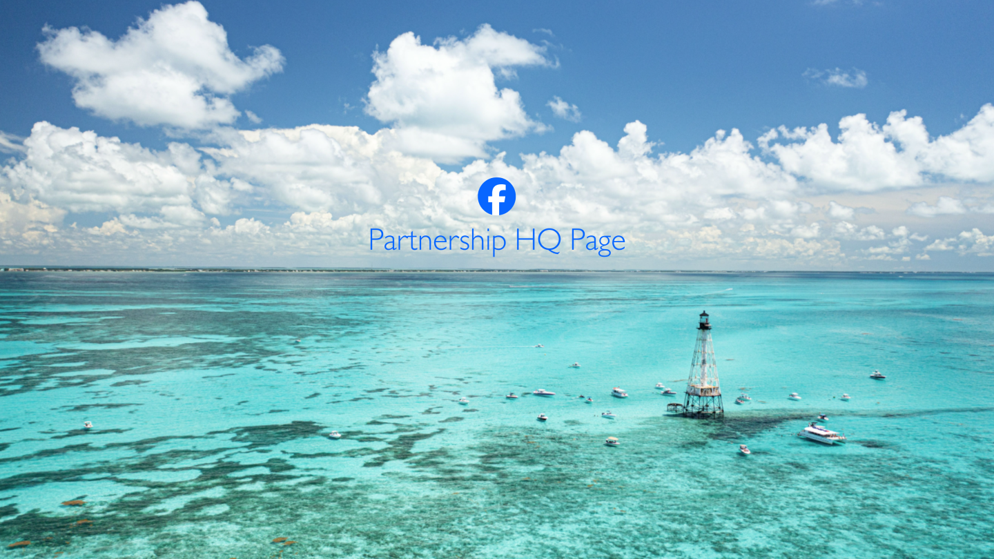Turquoise ocean with a lighthouse and distant island under clouds.