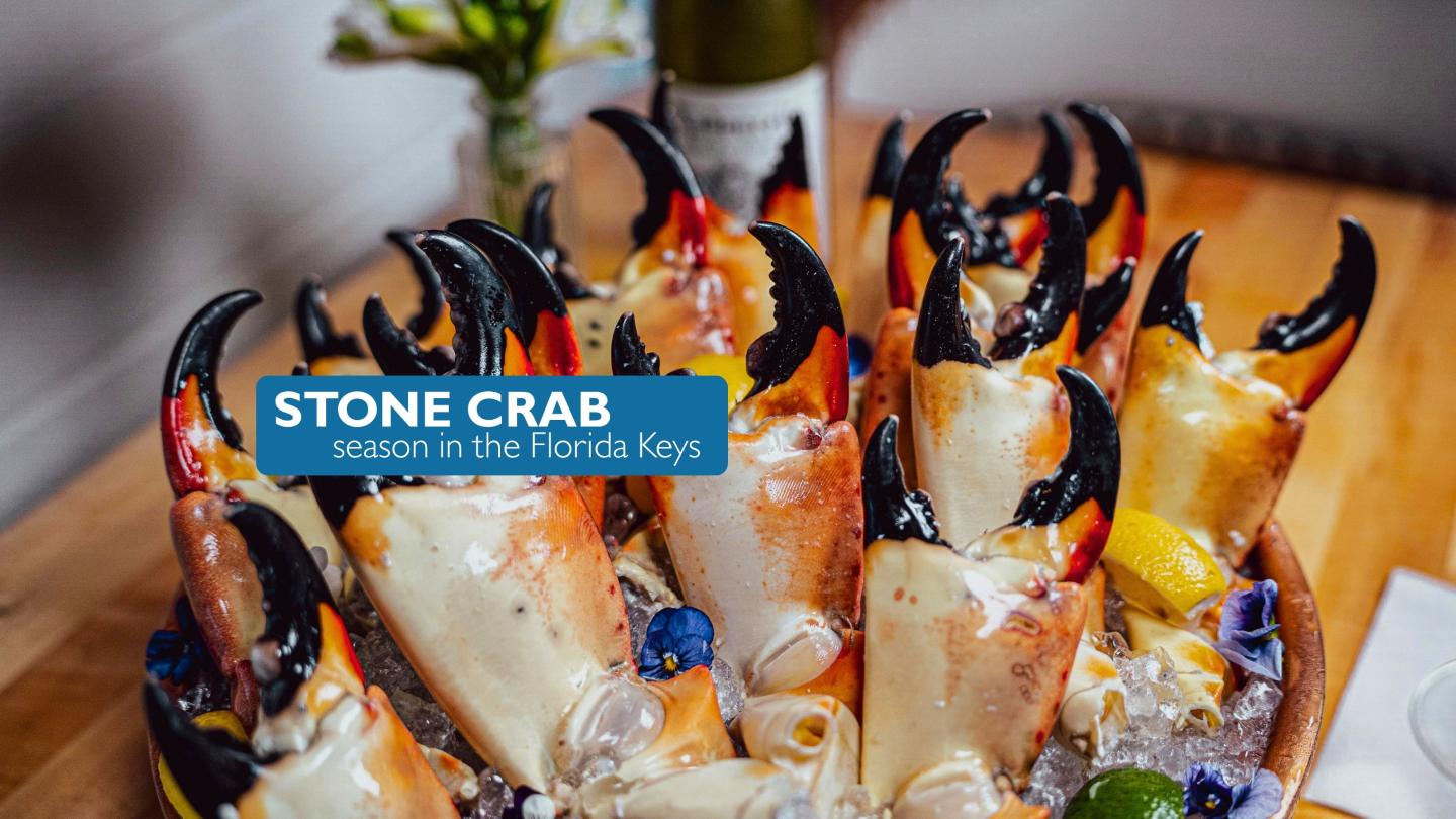 Three glasses of stone crab claws on ice, garnished with lemon wedges.