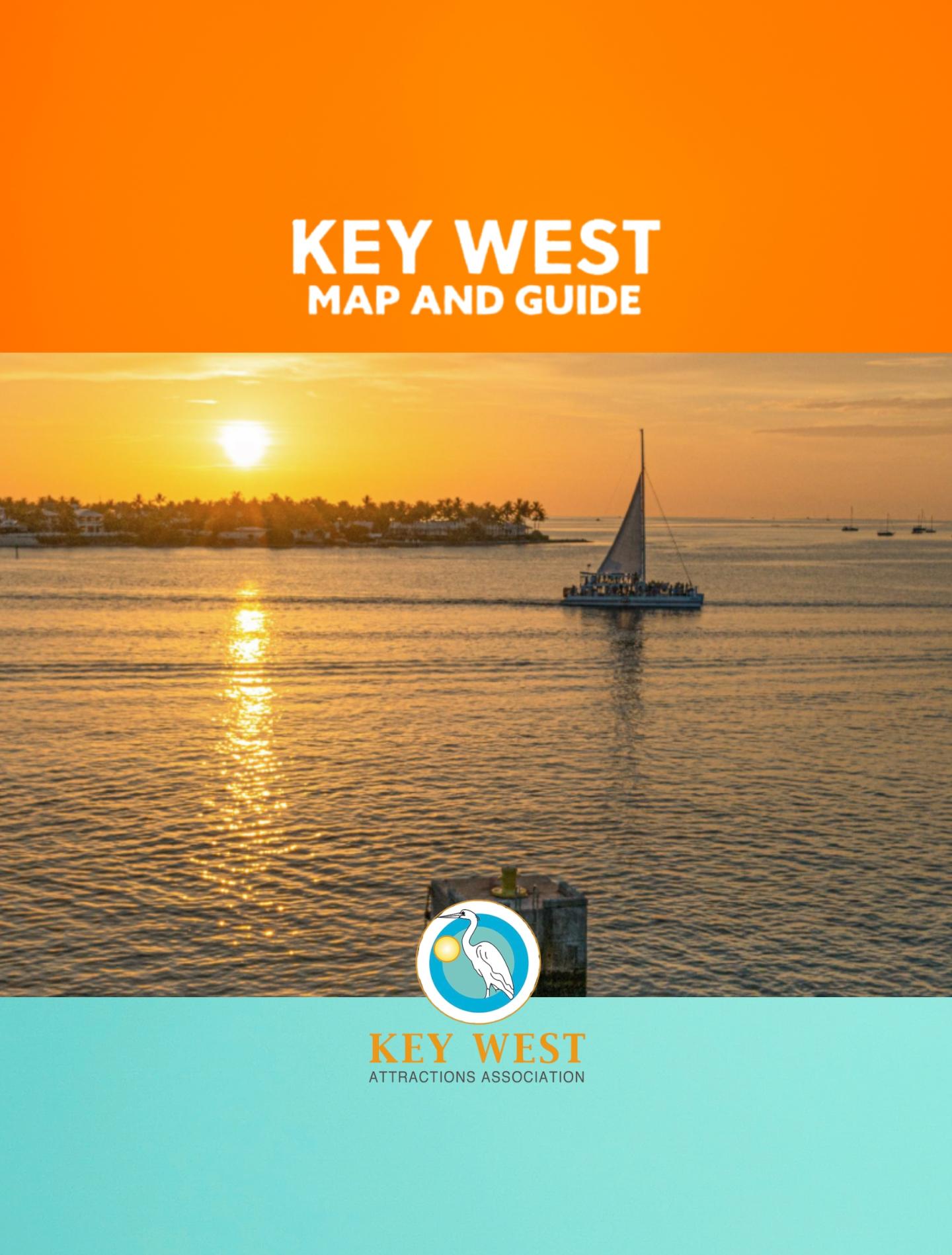 Sunset over Key West water with a sailboat and distant shoreline.