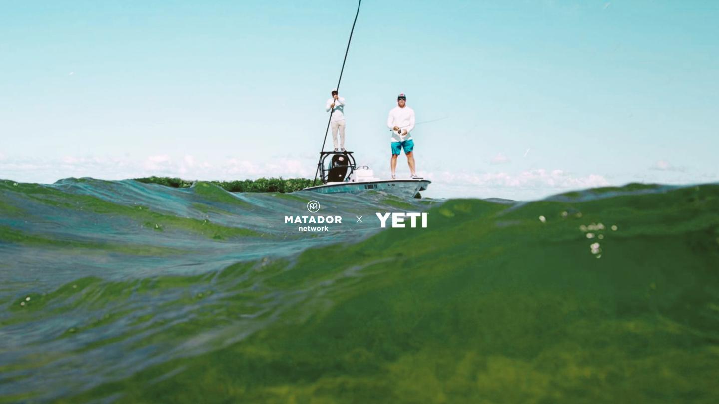 Wakeboarder riding a green wave, viewed from the water.