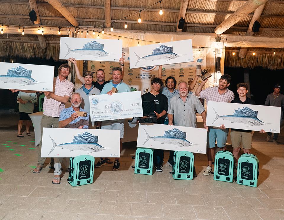 Group holding conservation artwork and certificates at an indoor event.