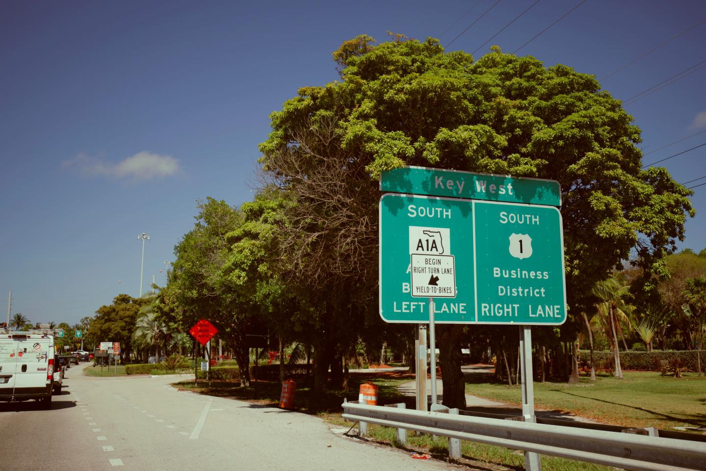 Green highway sign for Key Road and San Marino Boulevard at a tree-lined intersection.