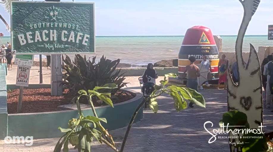Beach Café sign and colorful A-frame inflatable beside a seaside walkway.