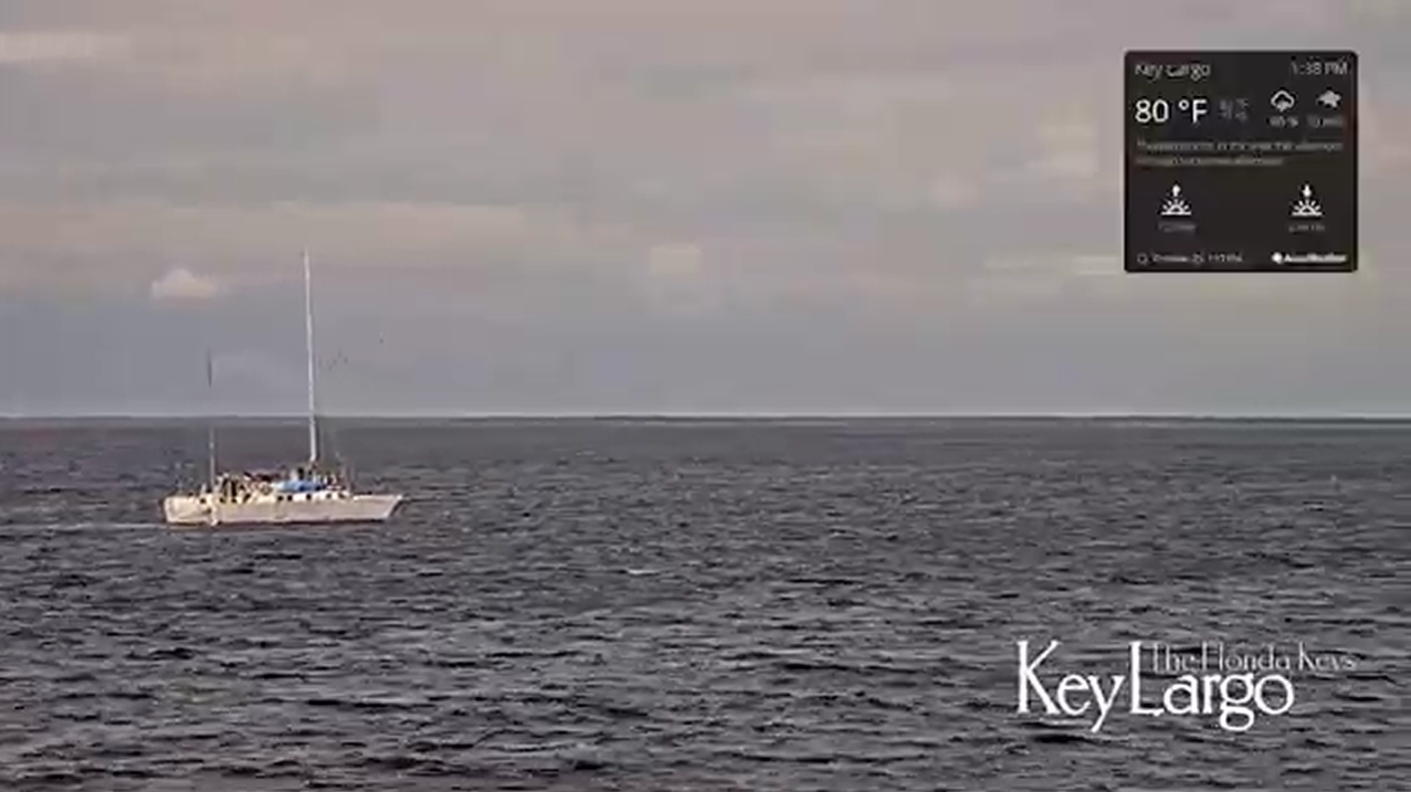 Sailboat on dark ocean beneath a cloudy sky, with Key Largo text in the corner.